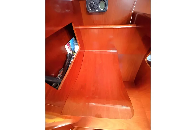 Brown Sugar Yacht Photos Pics Interior of 2005 Beneteau First 47.7 sailboat with wooden finish and storage compartment.