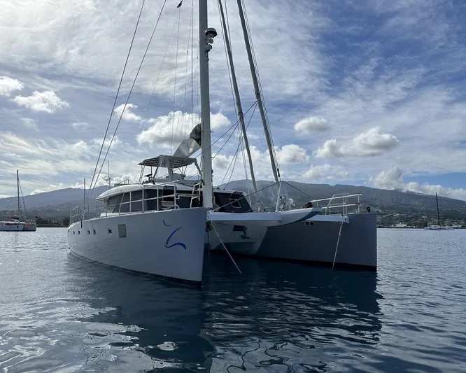 Zahora Yacht Photos Pics 2008 Sunreef 62 catamaran on calm water with mountainous backdrop.