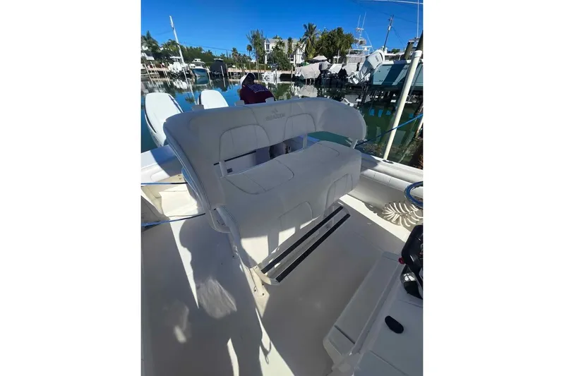  Yacht Photos Pics 2017 Regulator 25 boat interior with cushioned seating, docked at marina.