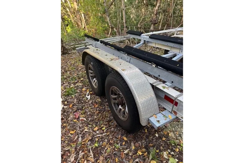  Yacht Photos Pics Trailer for 2017 Regulator 25 boat, parked on leaf-covered ground.