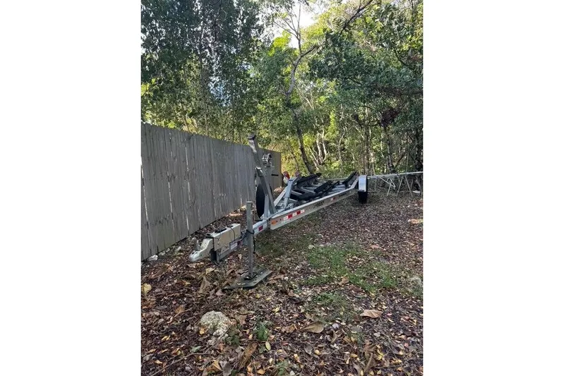  Yacht Photos Pics Trailer for 2017 Regulator 25 boat parked outdoors near a wooden fence.