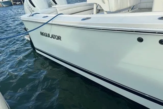  Yacht Photos Pics 2017 Regulator 25 boat docked on water, showcasing sleek white exterior design.