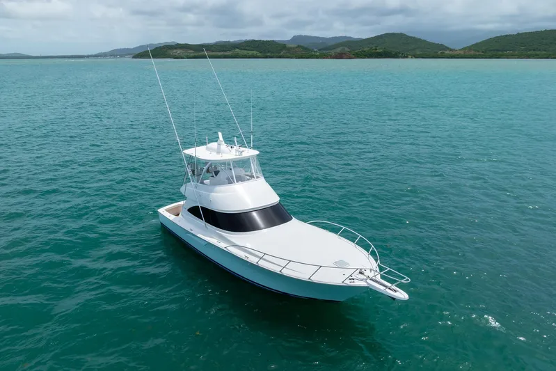 Insomnio Yacht Photos Pics 2022 Viking 48 Convertible yacht on turquoise water with scenic mountain backdrop.