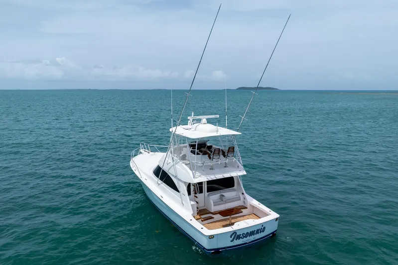 Insomnio Yacht Photos Pics 2022 Viking 48 Convertible yacht on open sea, clear sky, distant island.