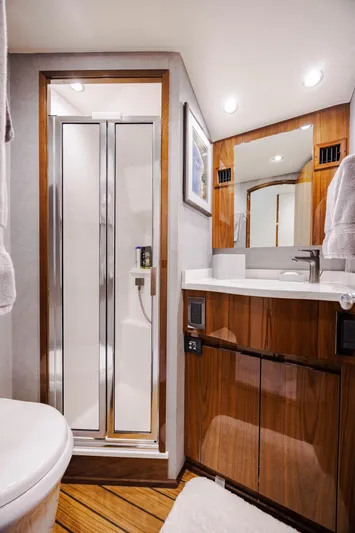 Insomnio Yacht Photos Pics Luxurious bathroom in 2022 Viking 48 Convertible yacht with modern fixtures and wood accents.