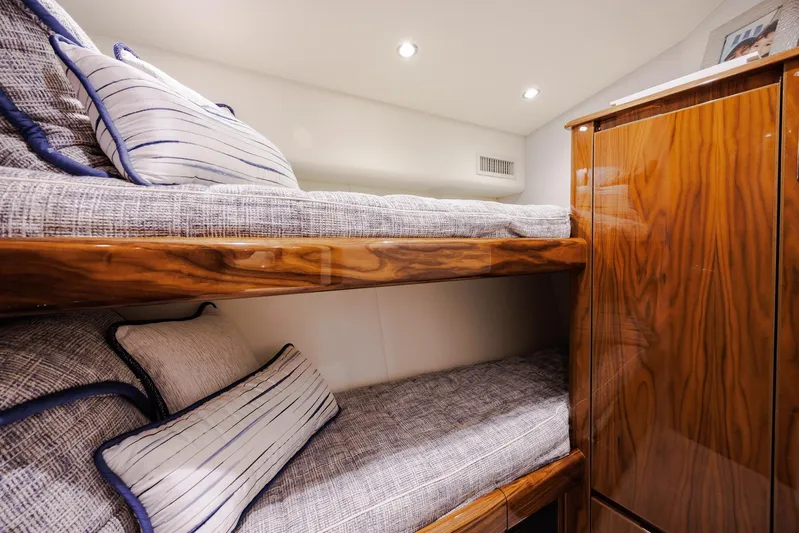 Insomnio Yacht Photos Pics Bunk beds in 2022 Viking 48 Convertible yacht cabin with wood finish and striped pillows.