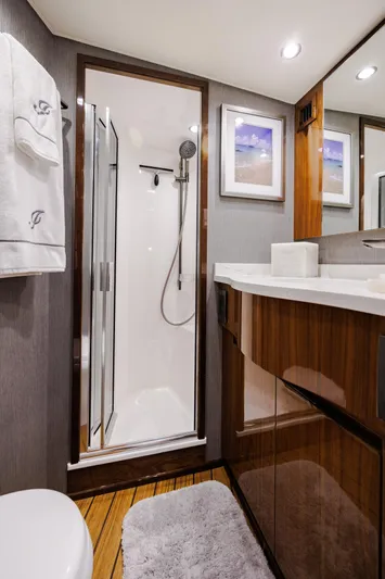 Insomnio Yacht Photos Pics Luxurious bathroom in 2022 Viking 48 Convertible yacht with modern shower and elegant wood finishes.