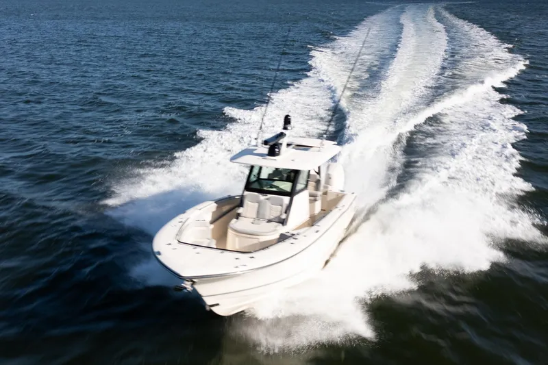 Natural 9 Yacht Photos Pics 2024 Scout 330 LXF boat cruising swiftly on open water.