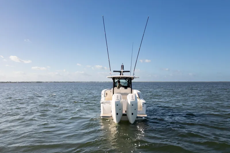 Natural 9 Yacht Photos Pics 2024 Scout 330 LXF boat on open water, rear view with dual engines.