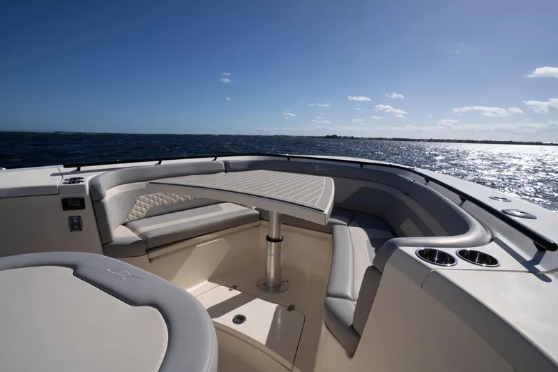 Natural 9 Yacht Photos Pics 2024 Scout 330 LXF boat interior with seating and table, overlooking the ocean.