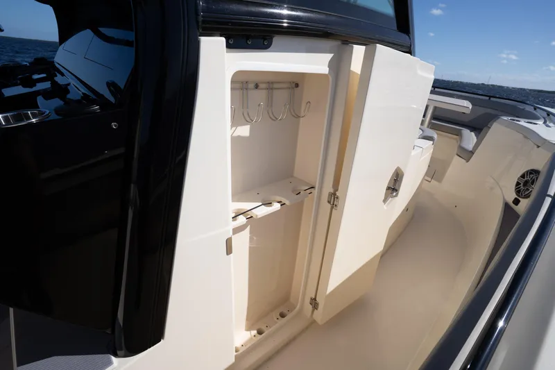 Natural 9 Yacht Photos Pics 2024 Scout 330 LXF boat interior with open storage compartment and hooks.