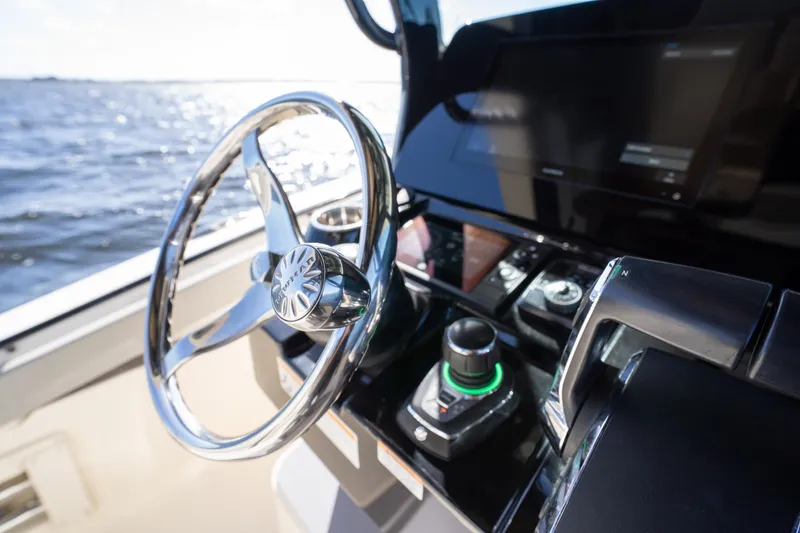 Natural 9 Yacht Photos Pics Steering wheel and controls of 2024 Scout 330 LXF boat on open water.