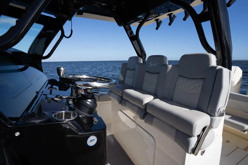 Natural 9 Yacht Photos Pics 2024 Scout 330 LXF boat interior with luxurious seating and steering wheel, on open water.