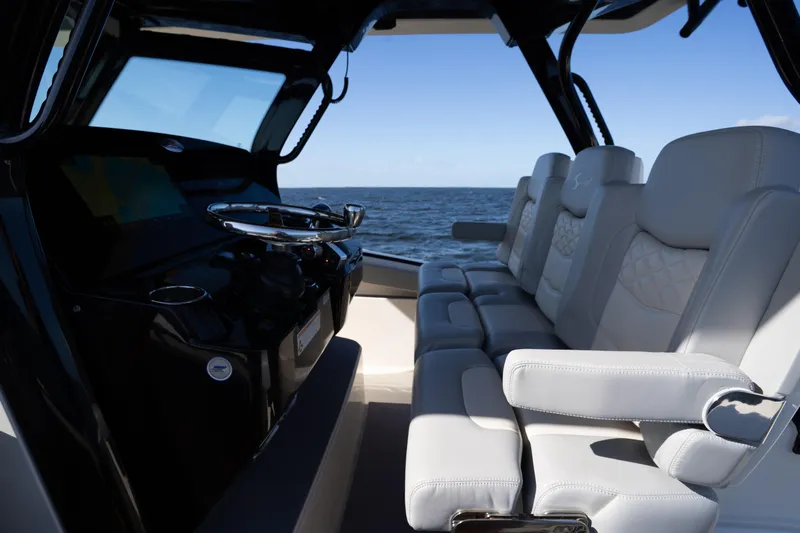 Natural 9 Yacht Photos Pics 2024 Scout 330 LXF boat interior with luxurious seating and steering console, ocean view.