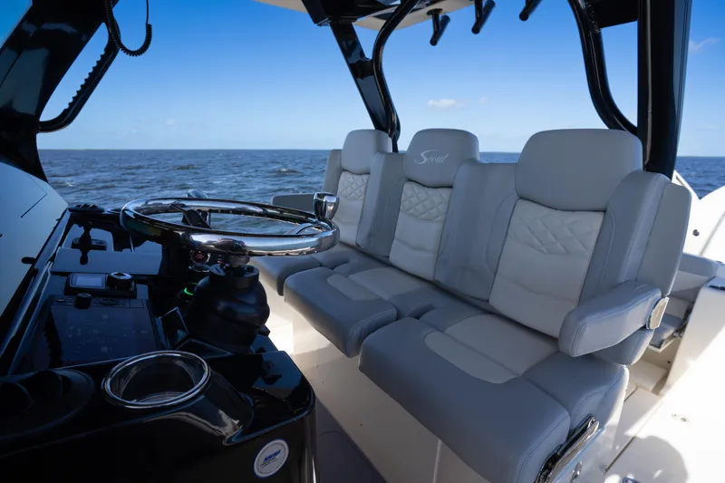 Natural 9 Yacht Photos Pics 2024 Scout 330 LXF boat interior with luxurious seating and steering wheel, ocean view.