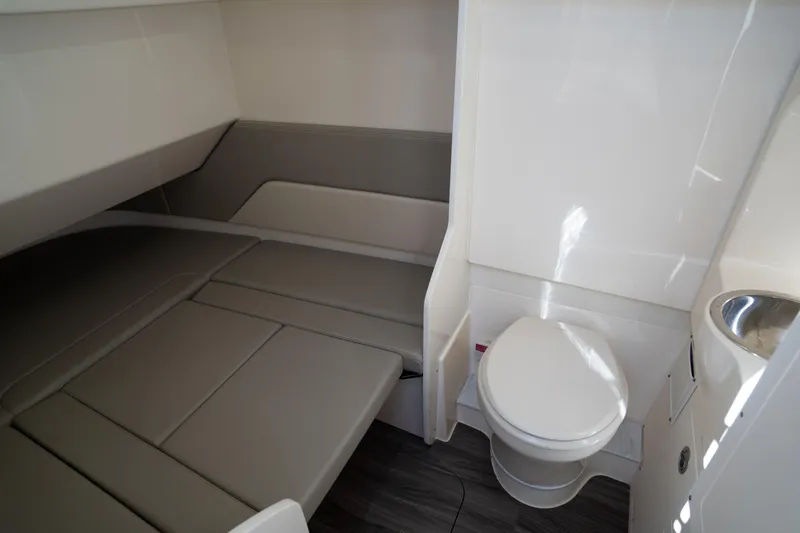 Natural 9 Yacht Photos Pics 2024 Scout 330 LXF cabin interior with bed, toilet, and sink.