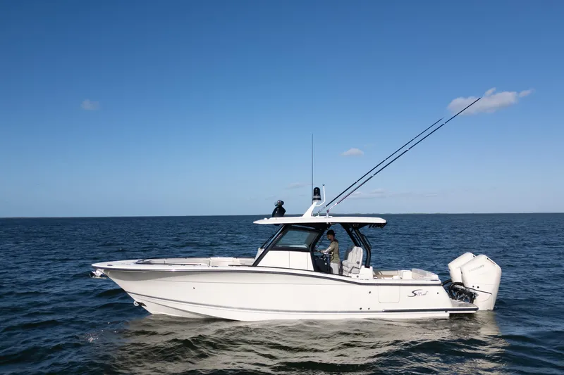 Natural 9 Yacht Photos Pics 2024 Scout 330 LXF boat cruising on open water under clear blue sky.