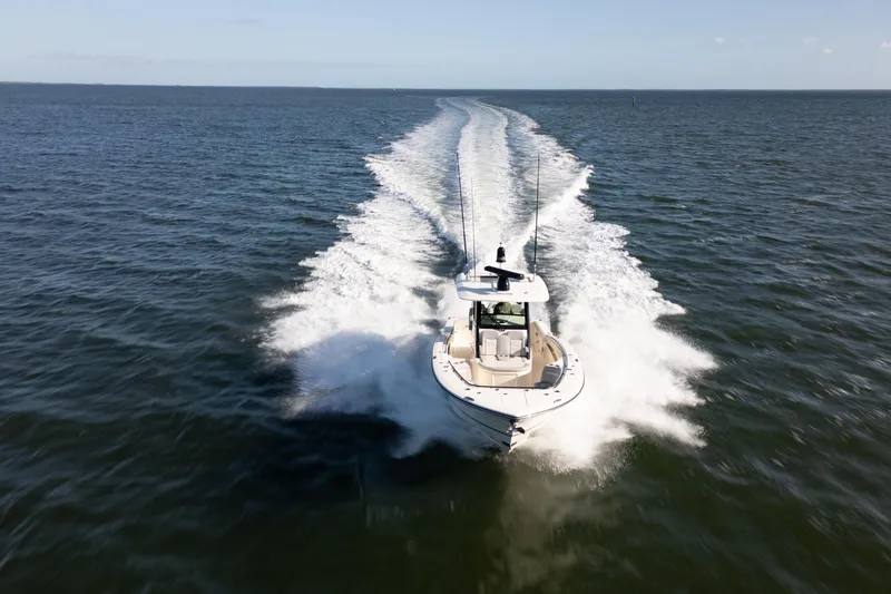 Natural 9 Yacht Photos Pics 2024 Scout 330 LXF boat cruising on open water, leaving a wake trail.