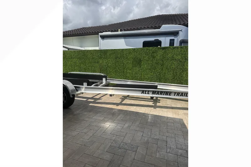 Natural 9 Yacht Photos Pics Trailer for 2024 Scout 330 LXF boat parked on paved driveway.