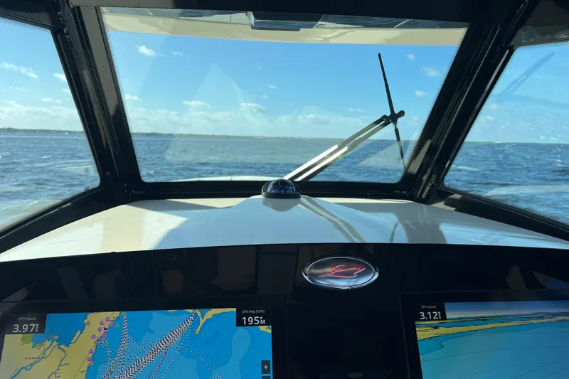 Natural 9 Yacht Photos Pics 2024 Scout 330 LXF boat dashboard with navigation screens, ocean view through windshield.