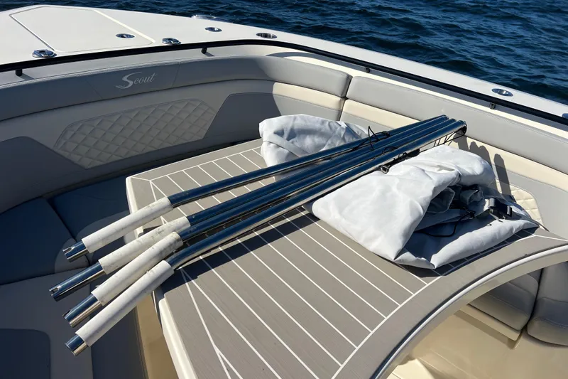 Natural 9 Yacht Photos Pics 2024 Scout 330 LXF boat interior with fishing rods on deck, ocean background.