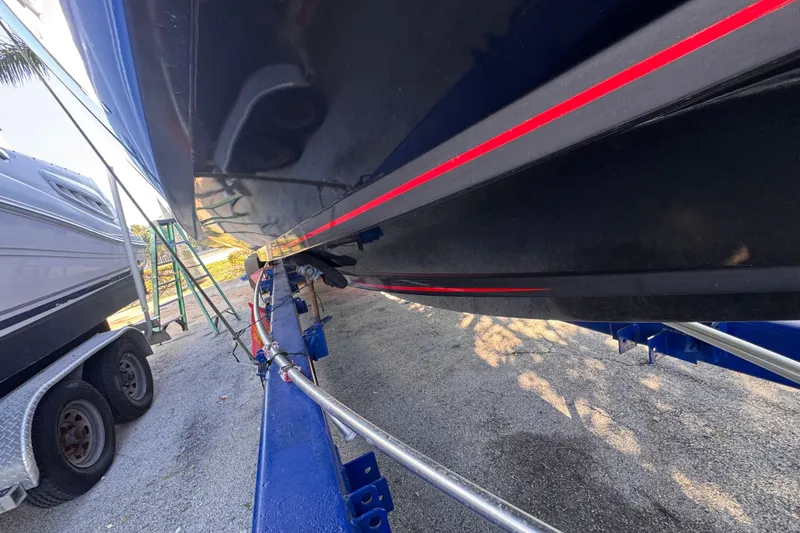  Yacht Photos Pics 2025 Don Smith Custom 55' boat on trailer, featuring sleek black hull with red stripe.