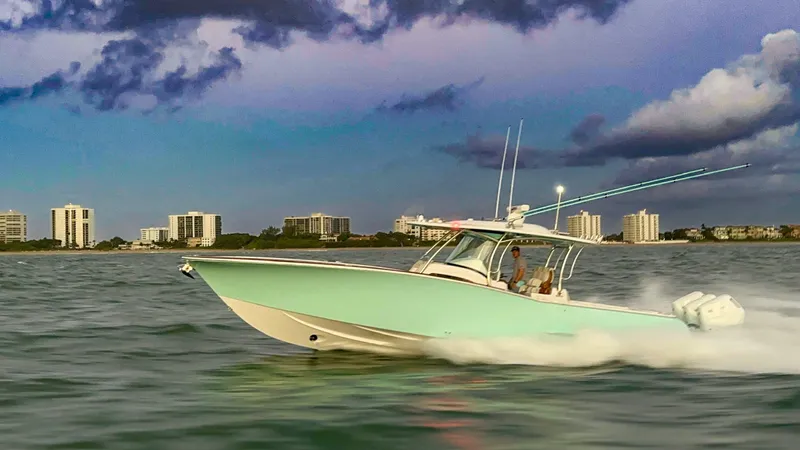  Yacht Photos Pics 2025 Mag Bay 38 CC boat cruising on water at sunset near city skyline.