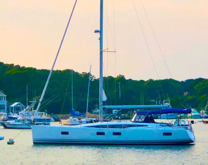 Caretta2 Yacht Photos Pics 2018 Jeanneau 54 sailboat anchored in a scenic harbor setting.