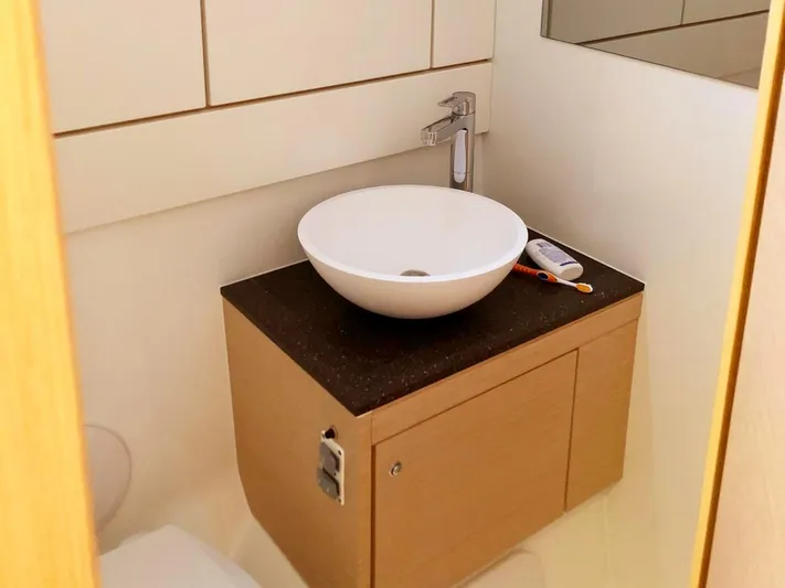 Caretta2 Yacht Photos Pics Modern bathroom vanity on 2018 Jeanneau 54 yacht with vessel sink and sleek faucet.