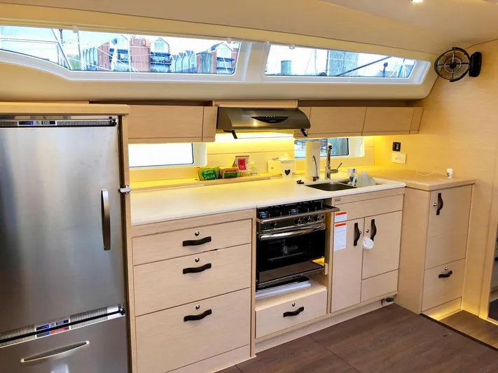 Caretta2 Yacht Photos Pics Modern kitchen interior of 2018 Jeanneau 54 yacht with stainless steel appliances and sleek cabinetry.