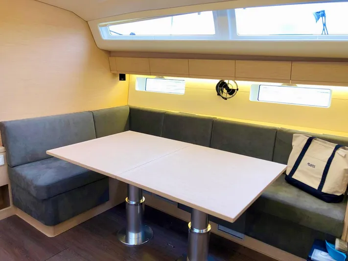 Caretta2 Yacht Photos Pics Interior of a 2018 Jeanneau 54 yacht with a modern dining area and cushioned seating.