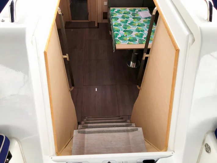 Caretta2 Yacht Photos Pics Stairway leading to the interior of a 2018 Jeanneau 54 yacht, featuring a colorful tablecloth.