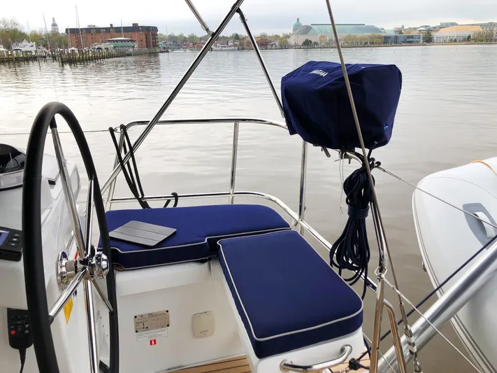 Caretta2 Yacht Photos Pics Cockpit view of 2018 Jeanneau 54 sailboat with blue cushions and scenic waterfront.