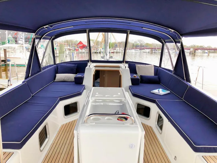 Caretta2 Yacht Photos Pics 2018 Jeanneau 54 yacht cockpit with blue seating and wooden flooring.