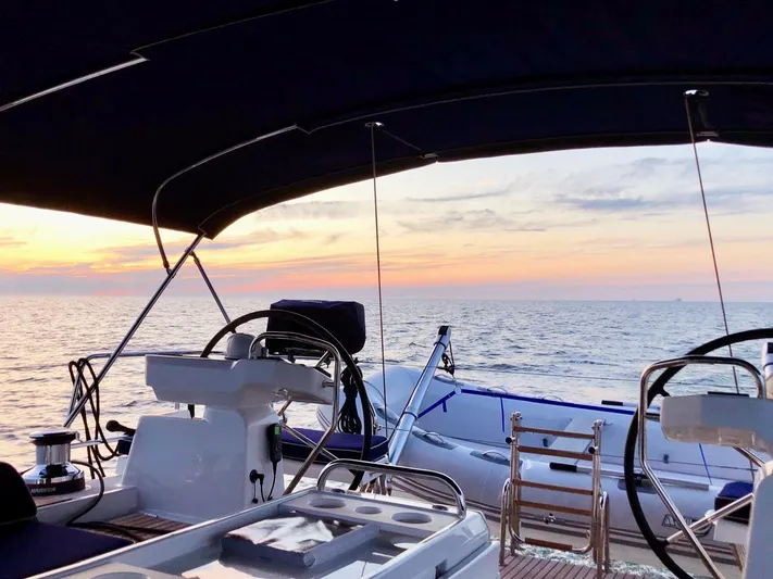 Caretta2 Yacht Photos Pics Jeanneau 54 sailboat deck at sunset, 2018 model, with ocean view.