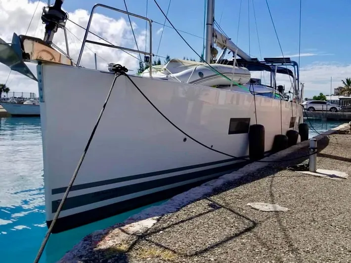 Caretta2 Yacht Photos Pics 2018 Jeanneau 54 sailboat docked at a marina, clear sky, calm water.