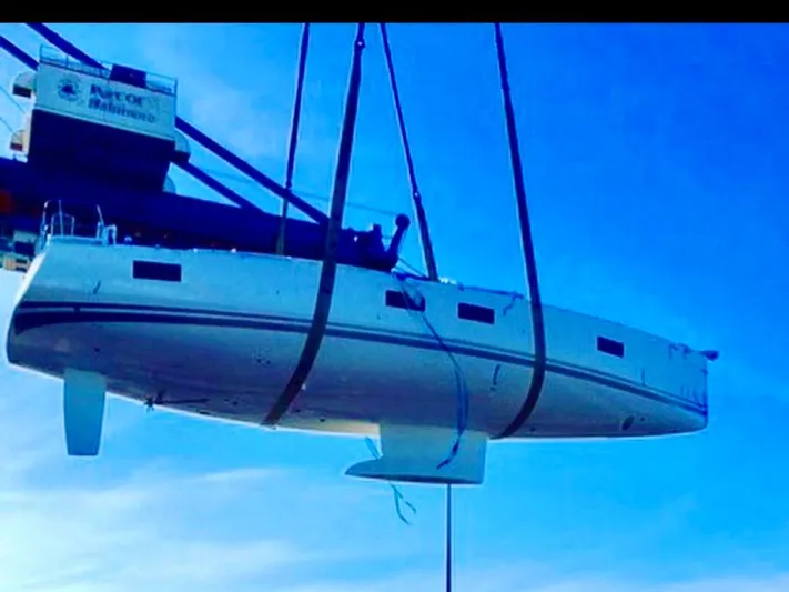 Caretta2 Yacht Photos Pics 2018 Jeanneau 54 yacht being lifted by crane against blue sky.