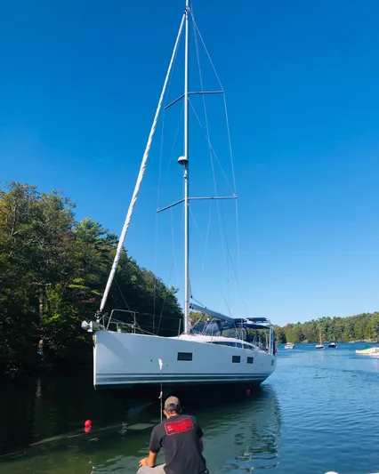 Caretta2 Yacht Photos Pics 2018 Jeanneau 54 sailboat on calm water with clear blue sky.