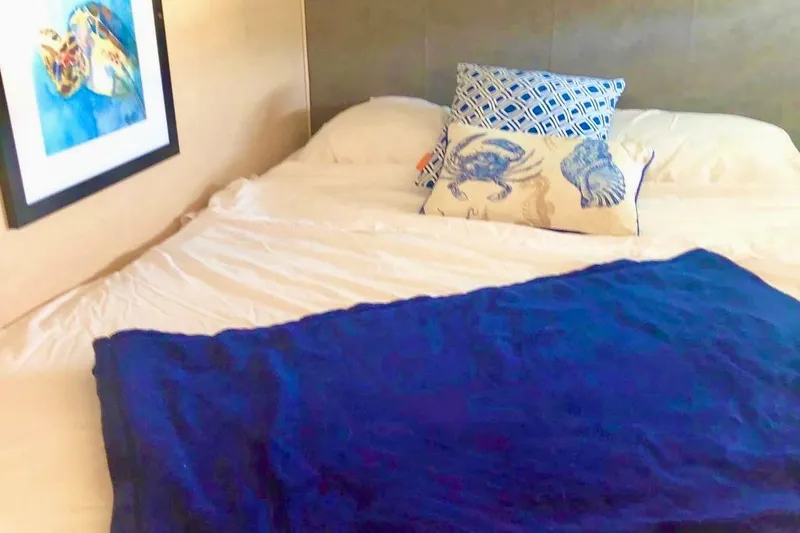 Caretta2 Yacht Photos Pics Cozy bedroom in 2018 Jeanneau 54 yacht with nautical-themed pillows and artwork.