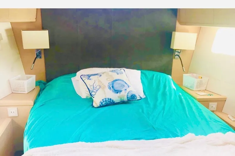Caretta2 Yacht Photos Pics Cozy bedroom in 2018 Jeanneau 54 yacht with teal bedding and decorative pillows.