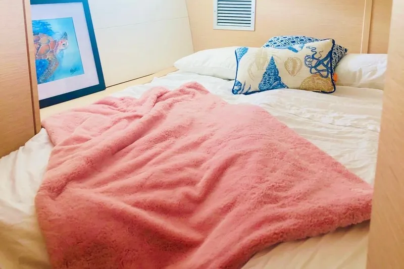 Caretta2 Yacht Photos Pics Cozy bedroom in 2018 Jeanneau 54 yacht with pink blanket and decorative pillows.