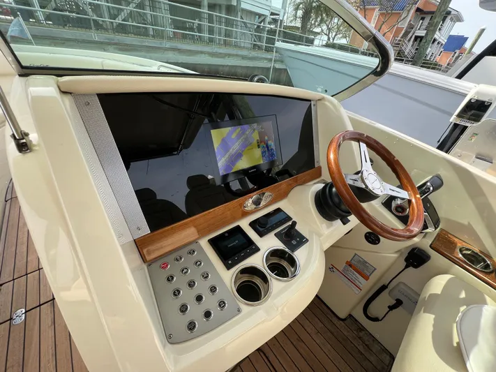  Yacht Photos Pics 2022 Chris-Craft Calypso 30 helm with wooden steering wheel and modern controls.