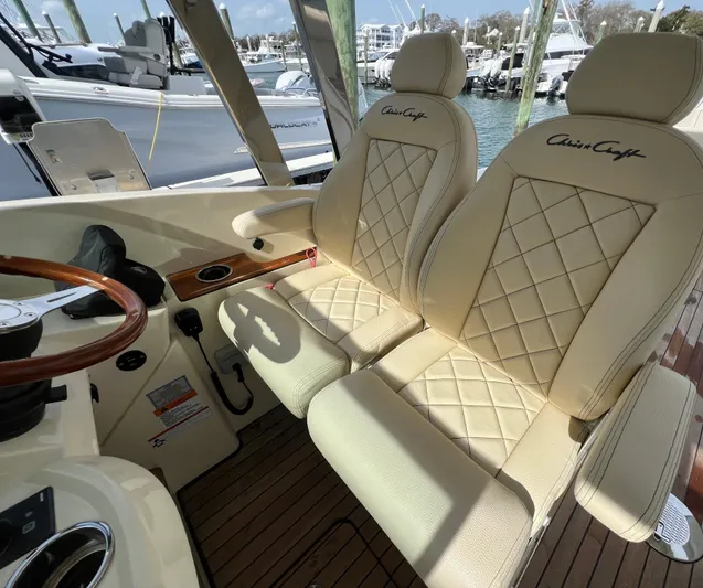  Yacht Photos Pics Luxurious 2022 Chris-Craft Calypso 30 boat interior with elegant cream seats and wooden accents.