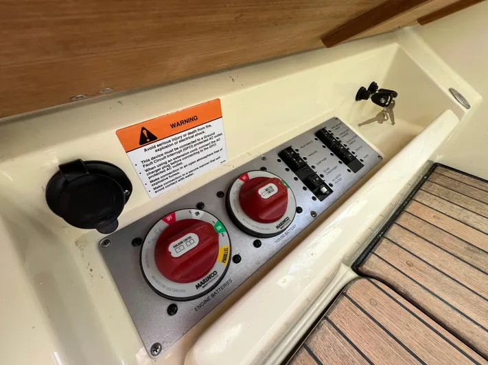  Yacht Photos Pics Control panel of 2022 Chris-Craft Calypso 30 boat with switches and warning label.