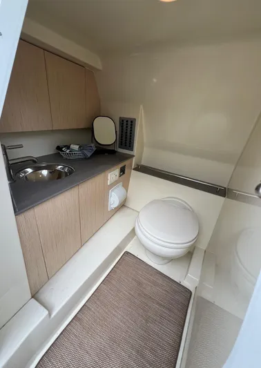  Yacht Photos Pics 2022 Chris-Craft Calypso 30 boat interior with compact bathroom, featuring sink and toilet.