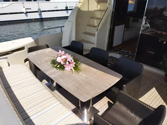  Yacht Photos Pics Outdoor dining area on 2009 Leonard 66 yacht with floral centerpiece and wicker chairs.