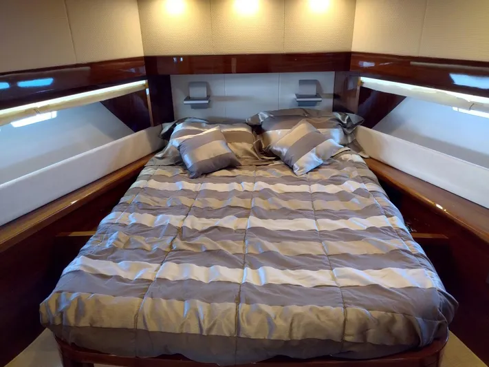  Yacht Photos Pics Luxurious bedroom interior of 2009 Leonard 66 yacht with striped bedding and ambient lighting.