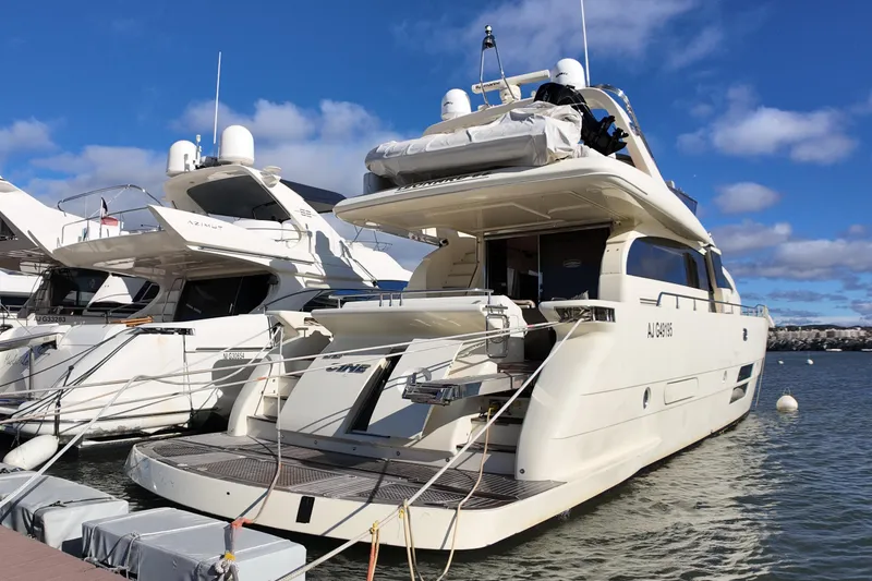  Yacht Photos Pics Luxurious Leonard 66 yacht from 2009 docked at a marina under clear blue skies.