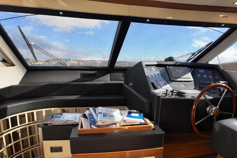  Yacht Photos Pics Pilothouse interior of 2009 Leonard 66 yacht with navigation controls and manuals.