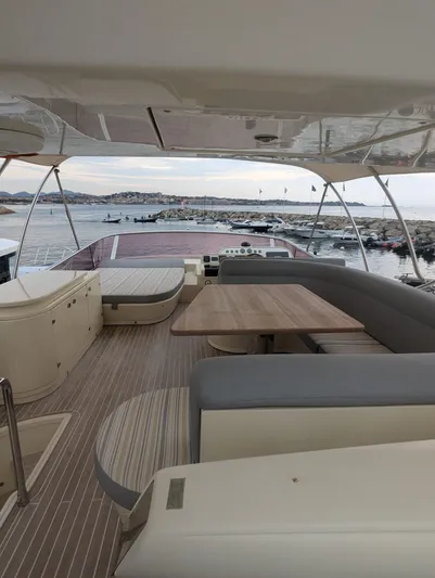  Yacht Photos Pics Luxurious Leonard 66 yacht interior with seating and table, overlooking a scenic marina view.